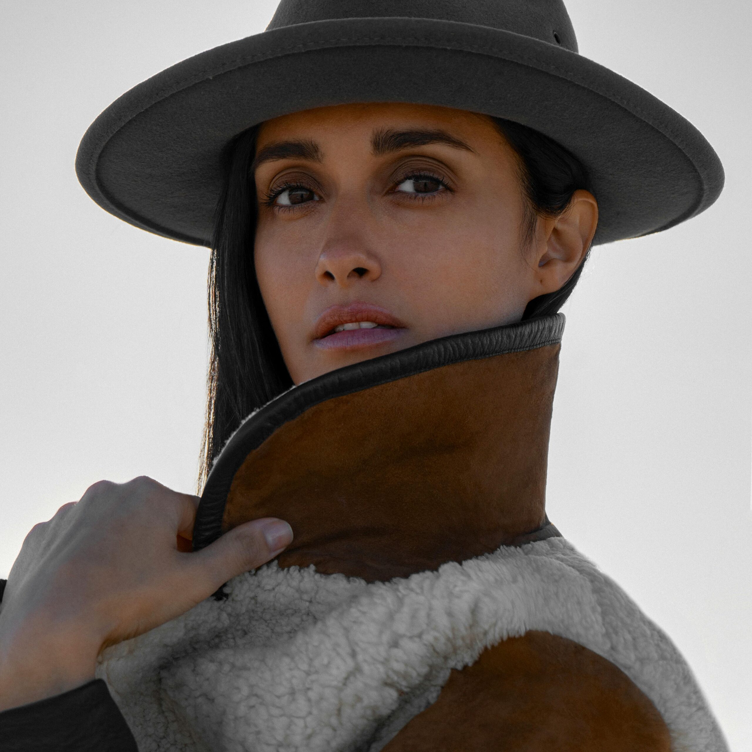 Home Portrait of a woman in a stylish hat and warm jacket with a confident look.