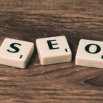 SEO Scrabble tiles spelling 'SEO' on a wooden surface. Ideal for digital marketing themes.